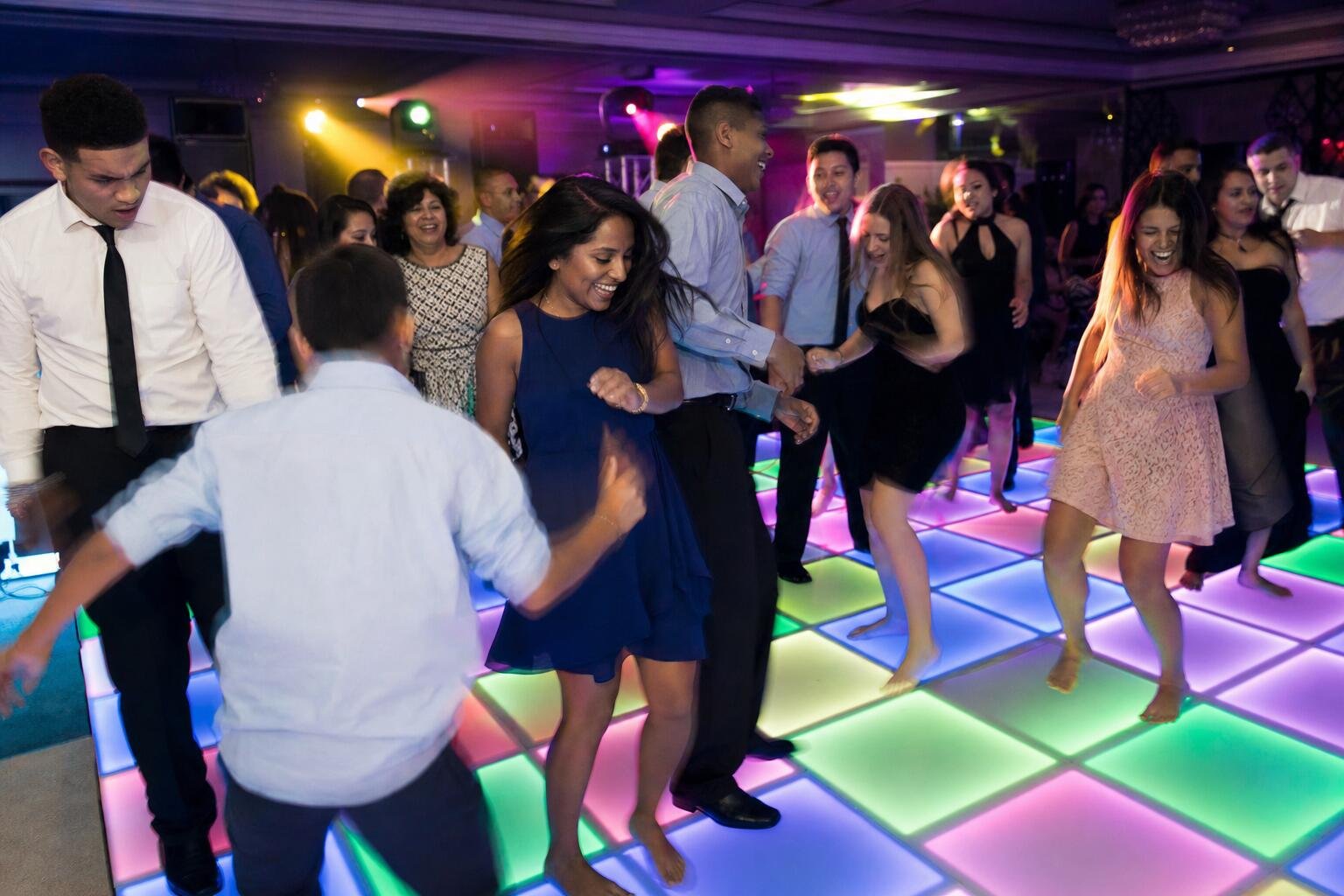 Guests dancing on a lit up LED dance floor at a party